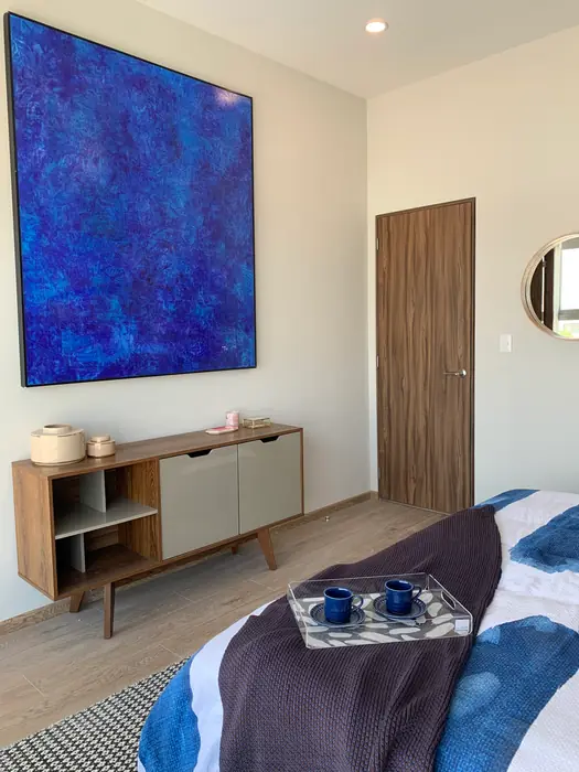 Recámara con pintura azul de gran formato y credenza