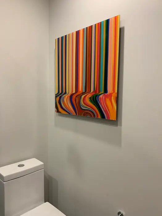 Baño de visitas con cuadro de rayas de colores