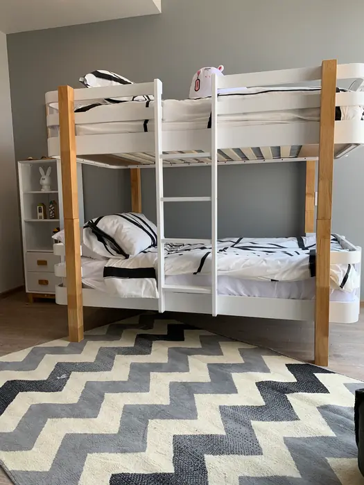 Recámara infantil con literas de madera y tapete en zigzag