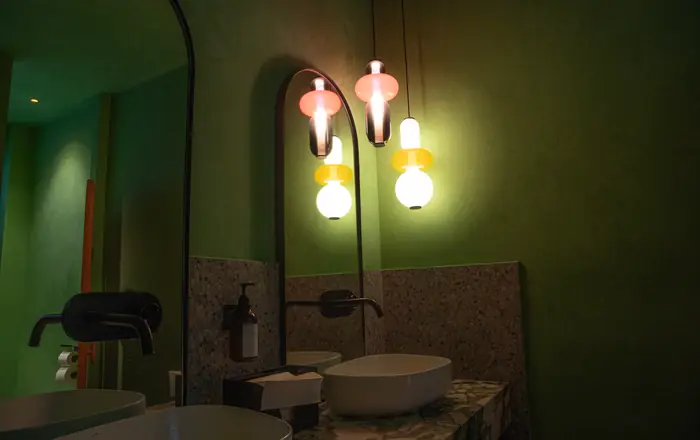 Lavabo con apliques sobre muro verde