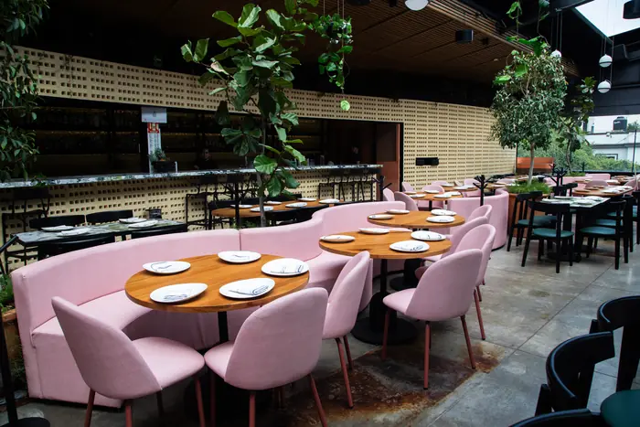 Salón con bancas rosas y celosía al fondo