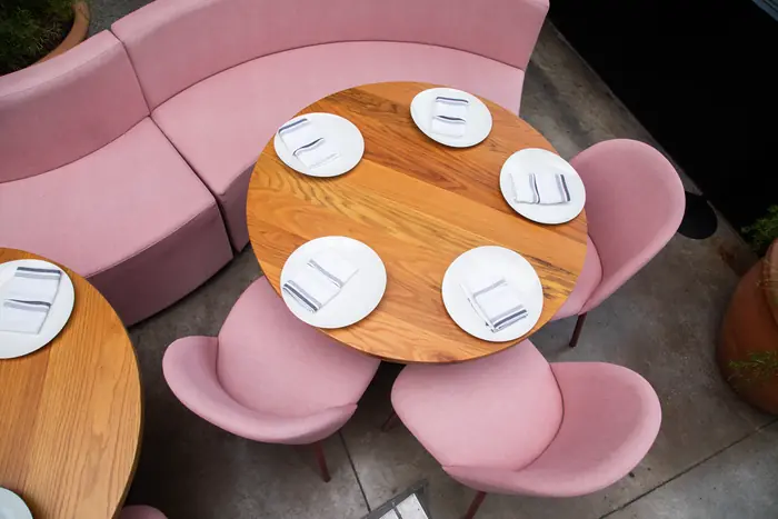 Mesa de madera con sillas rosas, vista cenital