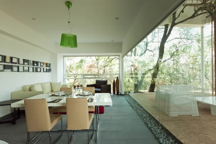 Comedor y sala con ventanal hacia el bosque