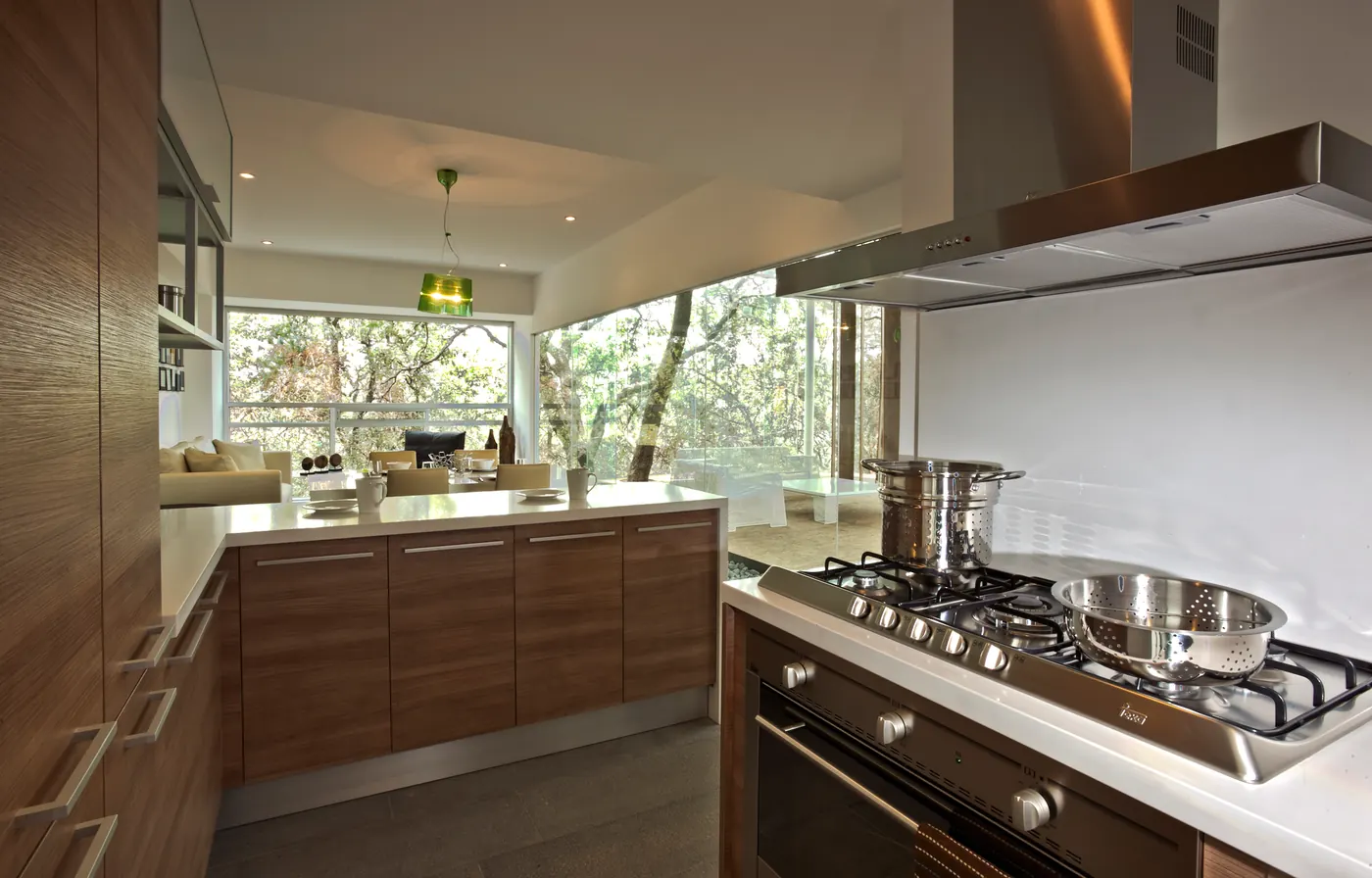 Cocina abierta de madera con vista al bosque