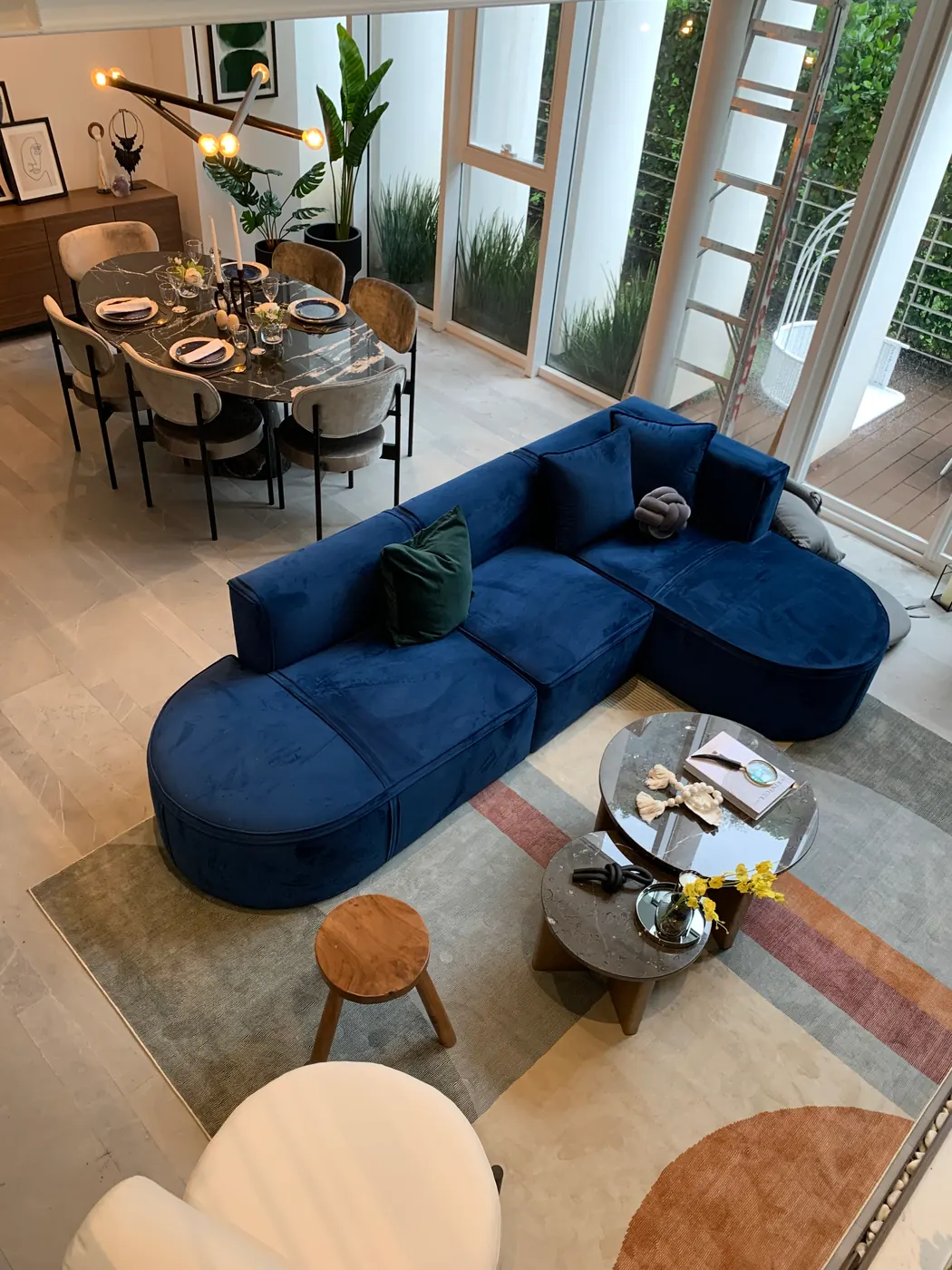 Sala de doble altura con sofá curvo de terciopelo azul, Blum Uno