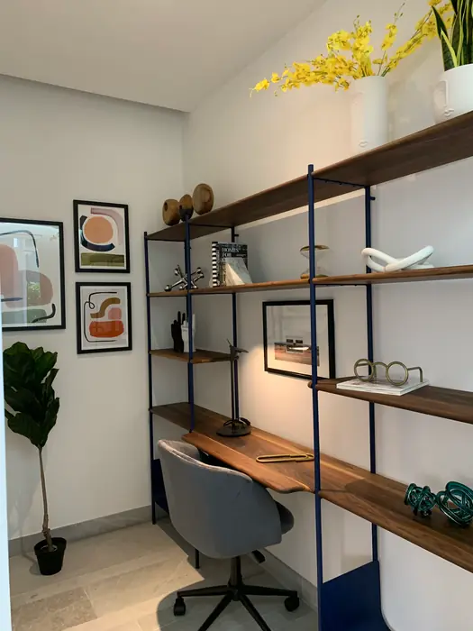 Estudio con librero metálico, escritorio de madera y arte