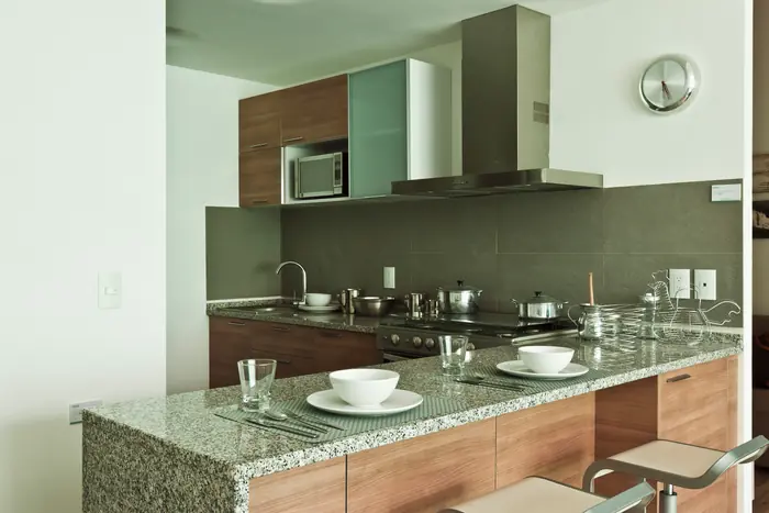 Cocina con barra de granito y gabinetes de madera