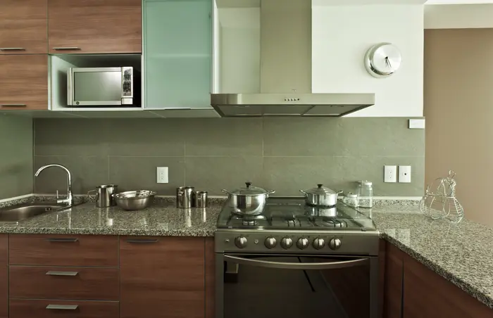 Cocina con cubierta de granito y campana de acero