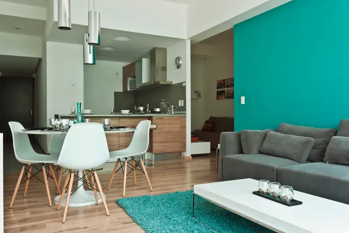 Comedor y sala con muro turquesa