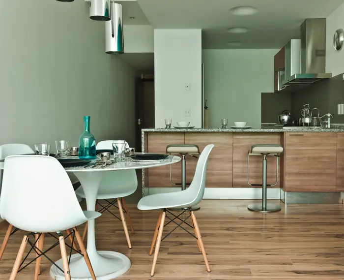 Comedor con sillas blancas frente a la cocina