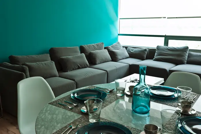 Sala modular gris con tapete turquesa
