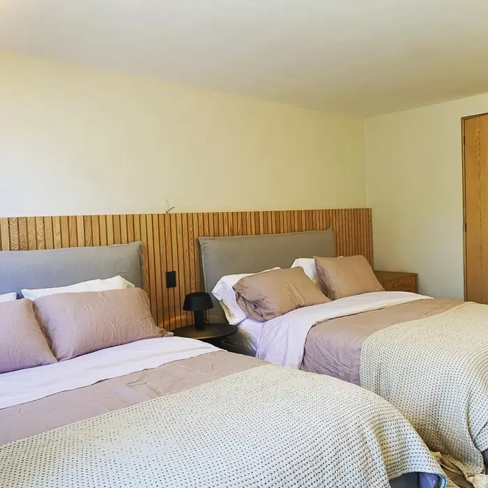 Recámara con dos camas, cabecera de listones de madera y textiles rosa