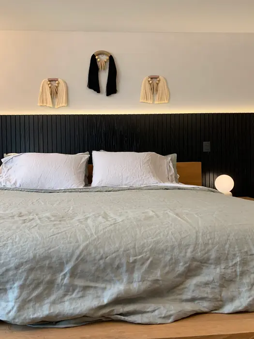 Recámara principal con lambrín negro y cama de madera
