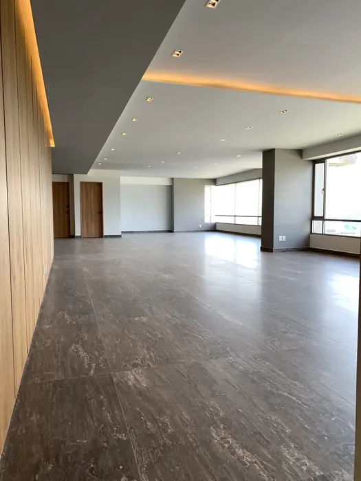 Estancia con muro de madera y plafón iluminado