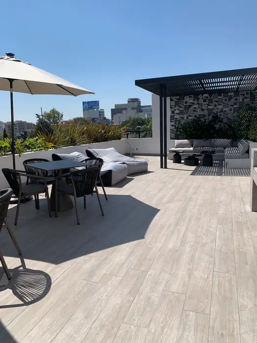 Roof garden con pérgola, comedor exterior y vista a la ciudad