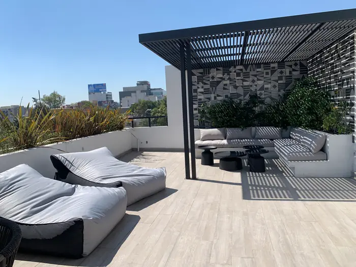 Terraza con camastros, sala exterior y pérgola