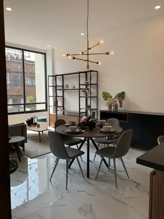 Comedor redondo con lámpara de latón junto a la ventana