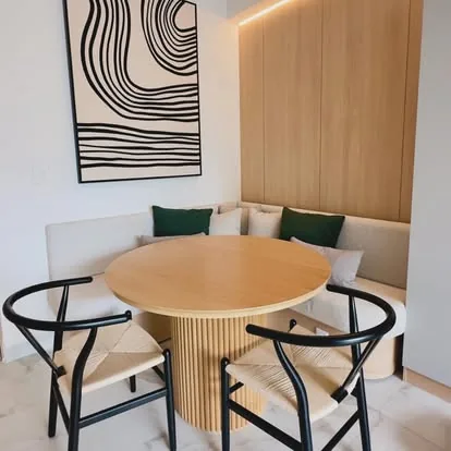 Desayunador con banca tapizada y mesa redonda de madera