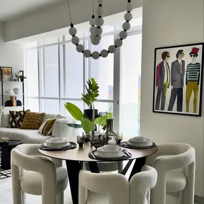 Comedor redondo con sillas tapizadas y arte