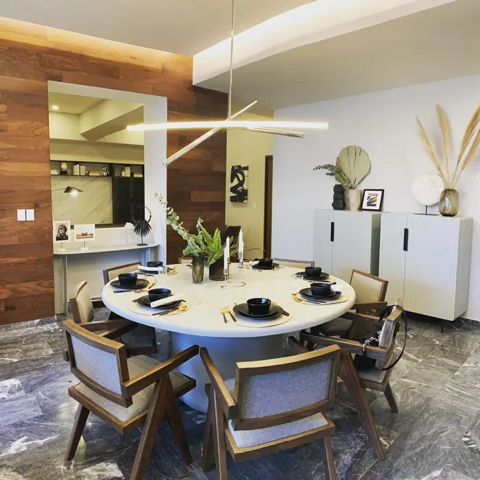 Comedor con lámpara lineal y muro de madera